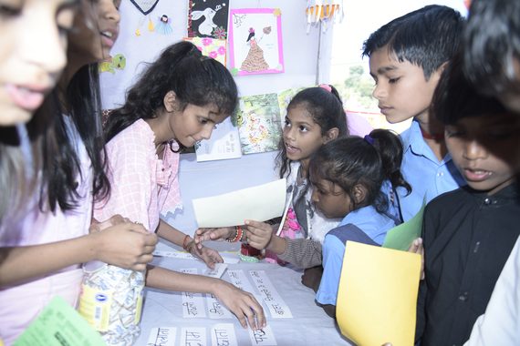 Children gathered around a table with books and learning materials